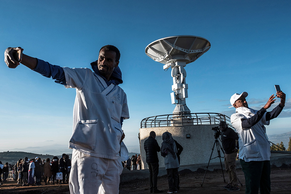 People take selfies in front of Ethiopian satellite antenna during ceremony for the Ethiopian Remote Sensing Satellite, which was launched by China.