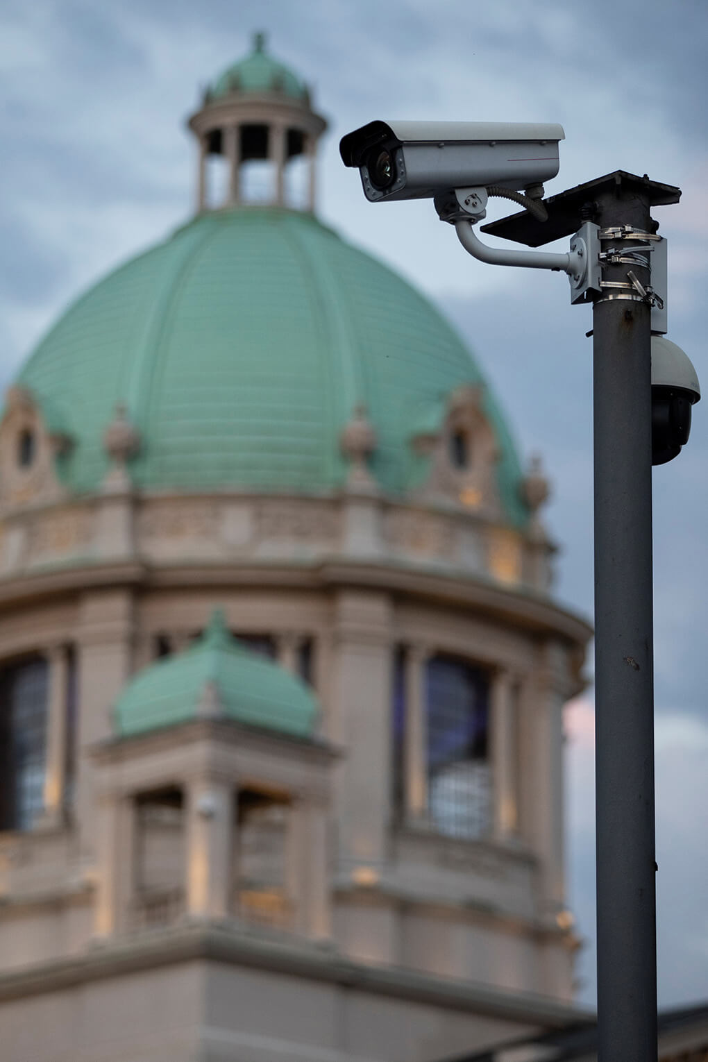 Surveillance camera stands in front of Serbia’s parliament building in Belgrade, in 2020. Chinese firms have helped Serbia implement a surveillance camera program.